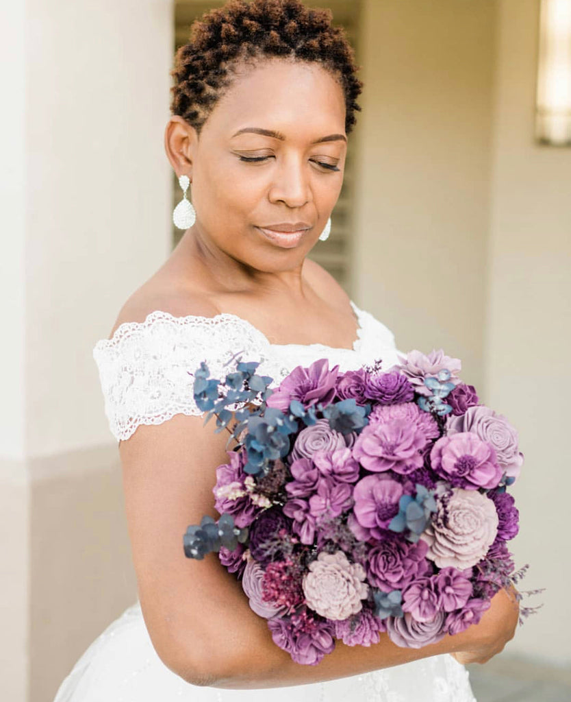 sola wood flower bridal wedding bouquet being held by a bride in plum purple