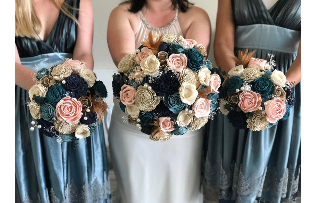 blue, navy and blush sola wood flower bouquet being held by a bride and bridesmaids
