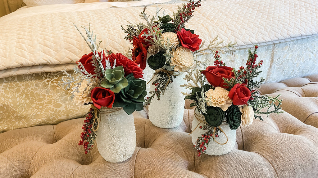 beautiful sola wood flower winter arrangements with frosted berries and pines by pine and petal market