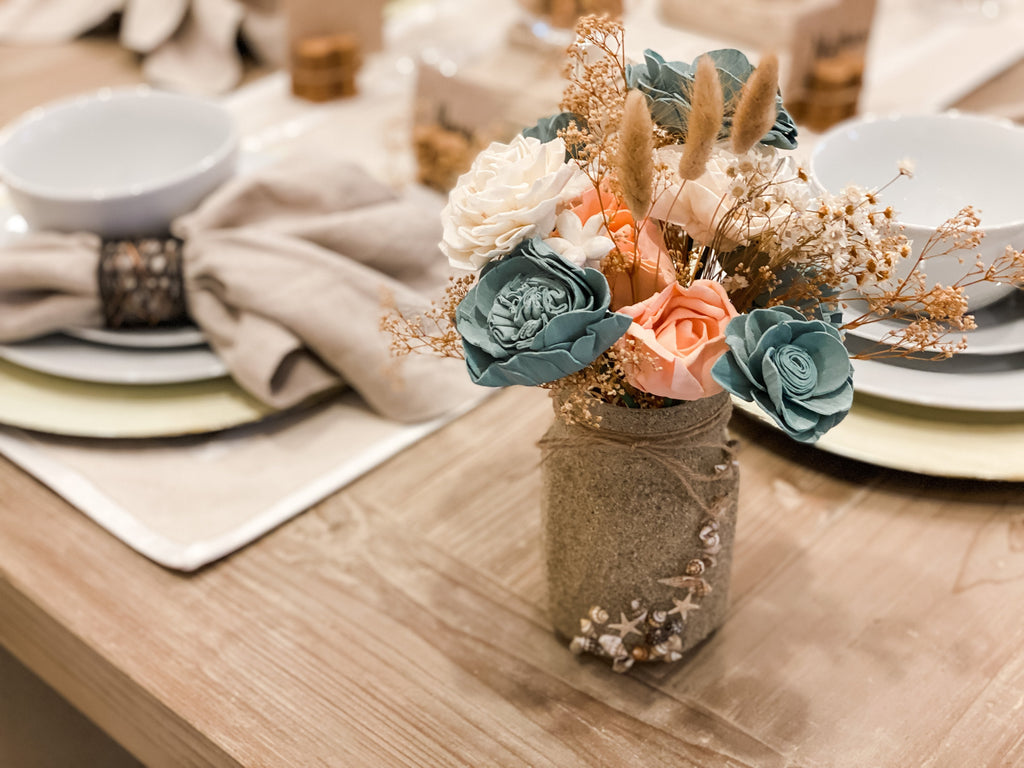 beautiful mason jar designs with sand and shells and a lasting sola wood forever flower arrangement
