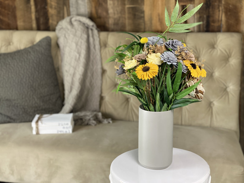 grey and beige sola wood flower arrangement with black eyed susans and daisies