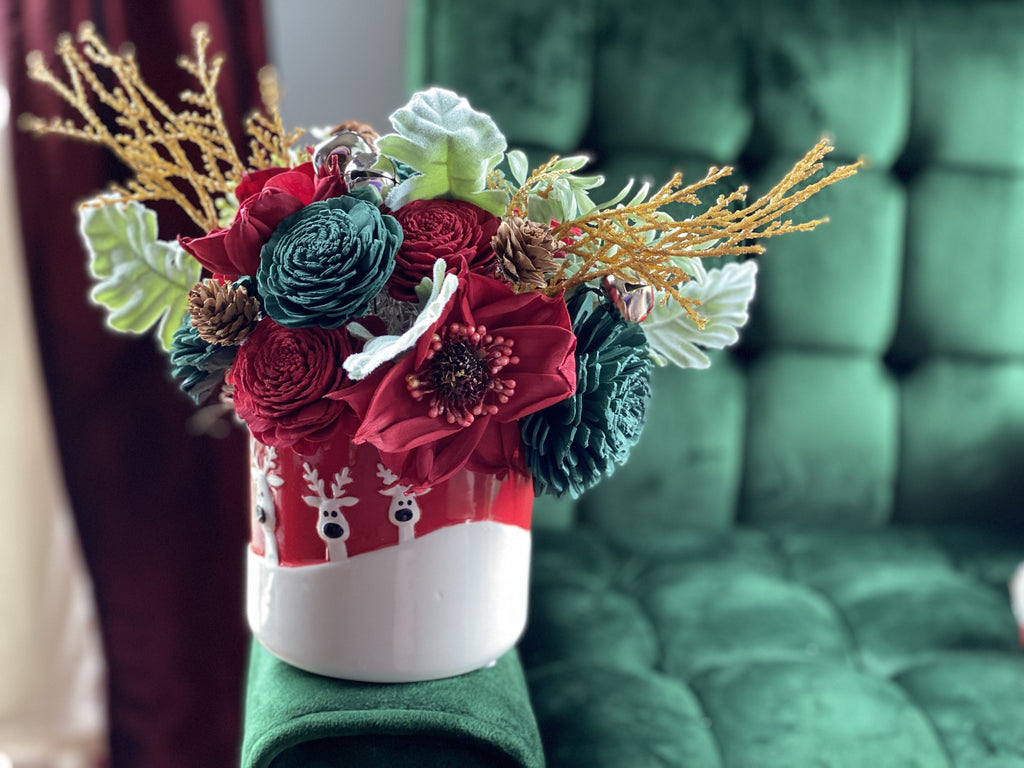 red and green sola wood flower arrangement with reindeer and gold