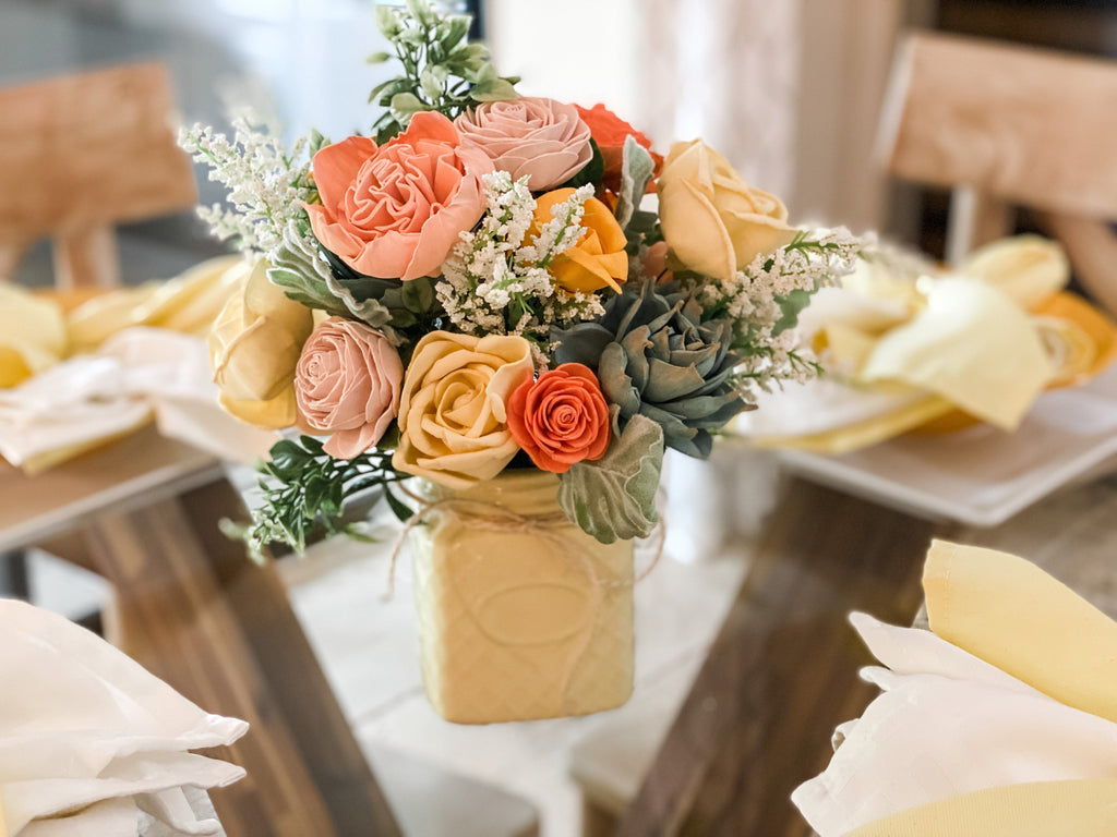 table floral centerpiece arrangement in yellow and coral and peach made of sola wood flowers